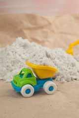 Fototapeta na wymiar Plastic toy truck on the sand. Construction, mining, construction equipment at work