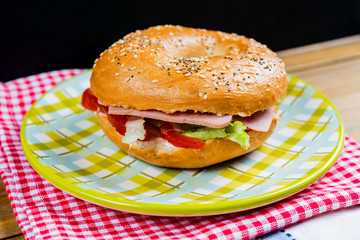 Bagel with fresh cheese and fresh lettuce on napkin