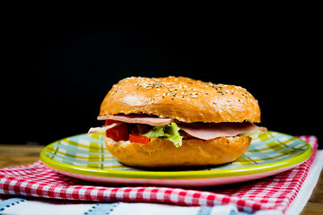 Bagel with fresh cheese and fresh lettuce on napkin