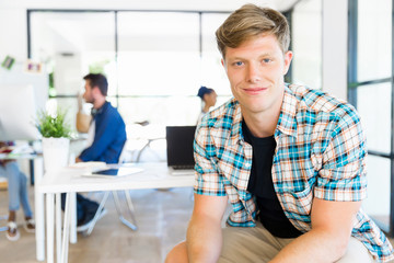 Young man sitting and looking at camera in office