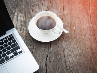 Obraz na płótnie Canvas Cup of black coffee on table with laptop