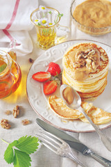 Pancakes with strawberries and herbal tea. Toned image