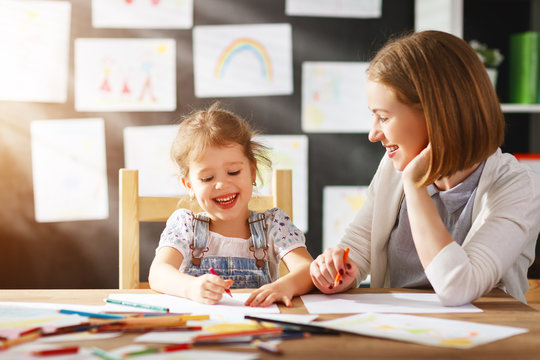 mother and child daughter draws in creativity in kindergarten