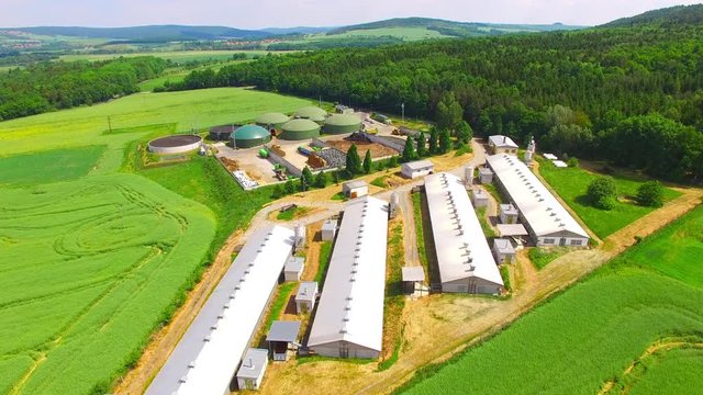Biogas plant and farm in green fields. Renewable energy from biomass. Aerial view to modern agriculture in Czech Republic and European Union. 