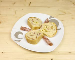 savory cake with salami, ham and cheese on wooden background - top view