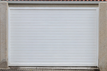 white garage door in a stone wall - Powered by Adobe