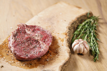 raw rib eye steak on board closeup, shallow focus