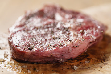 raw rib eye steak on board closeup, shallow focus
