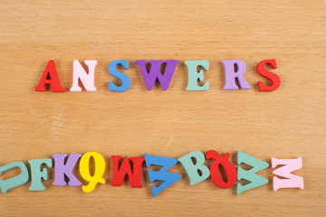 ANSWERS word on wooden background composed from colorful abc alphabet block wooden letters, copy space for ad text. Learning english concept.