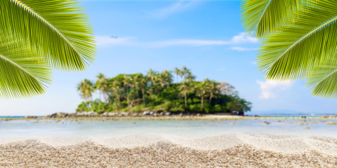 Sandy tropical beach with palm leaves frame and small island of andaman sea on background,concept summer holiday background.