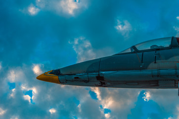 Part of a jet fighter monument against dramatic sky at sunset