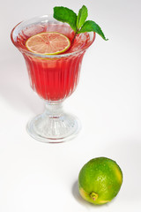 Cocktail with orange juice in a glass. Cherry, pomegranate juice, fresh. Mint leaves. Lime. Lemon. Decoration. Cocktail straw. Fresh with ice. Freshness. Cold drink. Alcohol Cocktail
