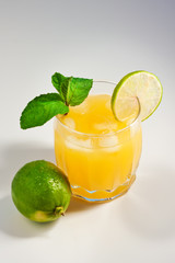 Cocktail with orange juice in a glass. Mint leaves. Lime. Orange fresh with ice. Freshness. Cold drink. Thirst quenching. Alcohol Cocktail
