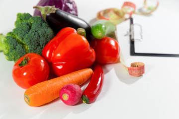 Fresh vegetables, measuring tape and diet plan