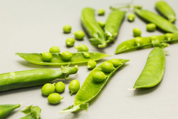 Farmer's organic young sweet pea on a gray background. Diet and health.