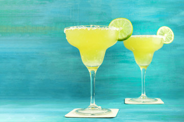 Lemon Margarita cocktails on vibrant turquoise with copyspace