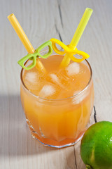 Cocktail with orange juice in a glass. Mint leaves. Lime. Orange fresh with ice. Freshness. Cold drink. Thirst quenching. Alcohol Cocktail
