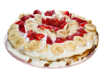 Sponge cake homemade with condensed milk decorated with banana slices and strawberries isolated on white background