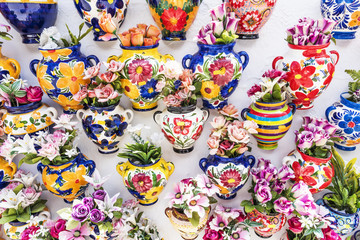 Colourful ceramic vases with flowers on a shop wall at Mijas - obrazy, fototapety, plakaty