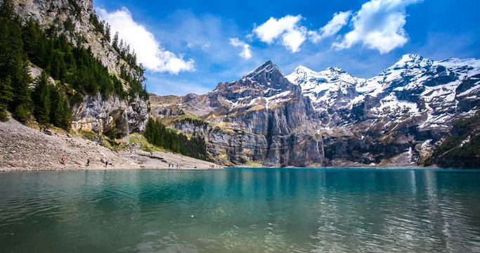 Amazing tourquise Oeschinnensee lake with waterfalls, wooden chalet and Swiss Alps, Berner Oberland, Switzerland. 
