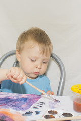 Portrait of a handsome boy is holding a paint brush.