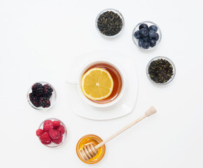 Herbal tea with honey, wild berry and flowers on white background. Flat lay, copy space