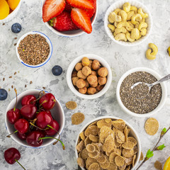 Ingredients for a healthy breakfast, nuts, oatmeal, honey, berries, fruits, blueberry, orange, pomegranate seed, almonds, walnuts The concept of natural organic food in season Top view