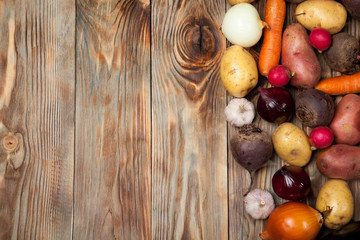Vegetables. Potatoes, carrots, onions, beets and radishes on a rustic background