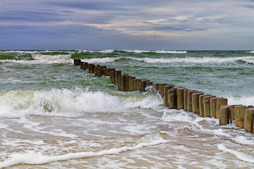 Plakaty  Drewniany falochron na wzburzonym morzu. Seascape, Morze Bałtyckie w pobliżu Kłajpedy, Litwa.