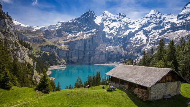Amazing tourquise Oeschinnensee lake with waterfalls, wooden chalet and Swiss Alps, Berner Oberland, Switzerland. 

