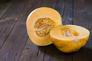 Melon cut in half on a wooden background