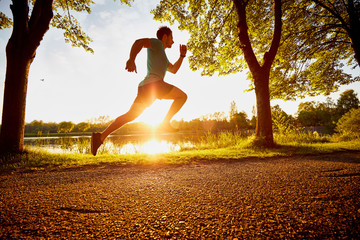 man running fast in park during sunset