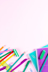 School stationery on pink background with copyspace