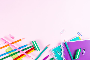 School stationery on pink background with copyspace