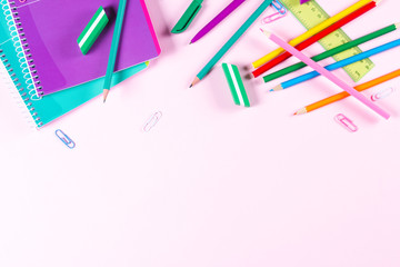 School stationery on pink background with copyspace