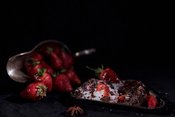 White icecream with chocolate and strawberry on the black background