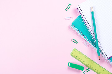 School stationery on pink background with copyspace
