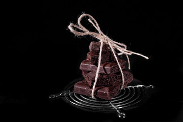 Stack of black pore chocolate on a black background