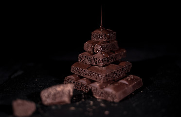 Stack of black pore chocolate on a black background