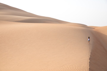 Beautiful woman hiking on giant sand dunes.