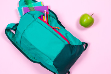 Naklejka premium Backpack with school stationery on pink background
