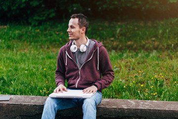 Obraz premium Handsome Young Man Working on Laptop Outside His Office, Freelance Concept