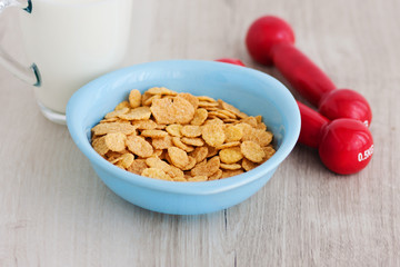 Milk, corn flakes, candied fruits and dumbbells. Healthy food. Breakfast champion. Restoration of forces. Growth and development
