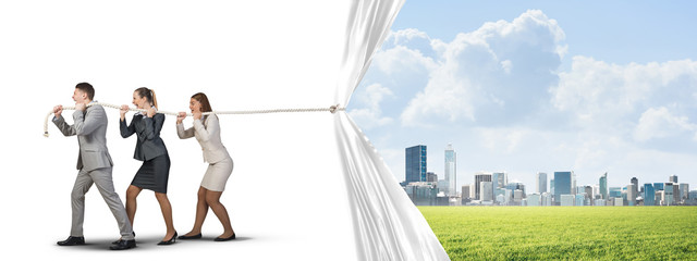 Obraz premium Young businesspeople working in collaboration and pulling white advertisement banner