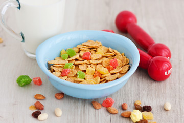 Milk, corn flakes, candied fruits and dumbbells. Healthy food. Breakfast champion. Restoration of forces. Growth and development
