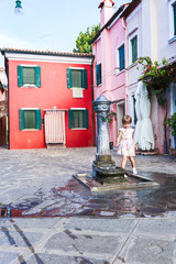 Obraz premium The girl washes hands in fountain. The first acquaintance with fountains of island of Burano