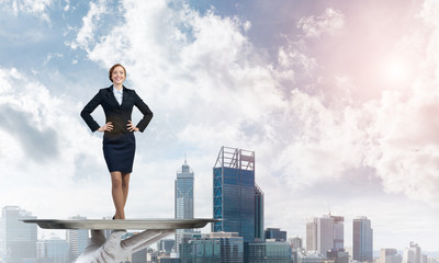 Confident elegant businesswoman presented on metal tray against cityscape background