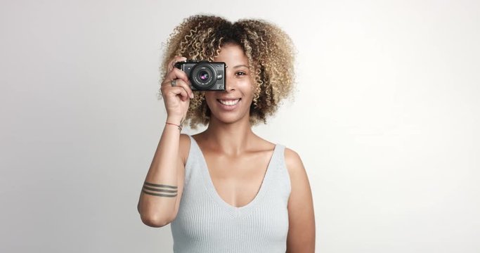 happy smiling black woman with afra makes shoots with photocamera