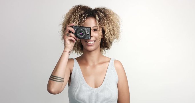 happy smiling black woman with afra makes shoots with photocamera