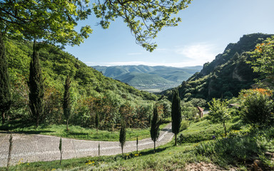Fototapeta na wymiar Beautiful Georgian landscape with stone road and hills on the skyline. Caucasus nature in summer. Tourism in Georgia.